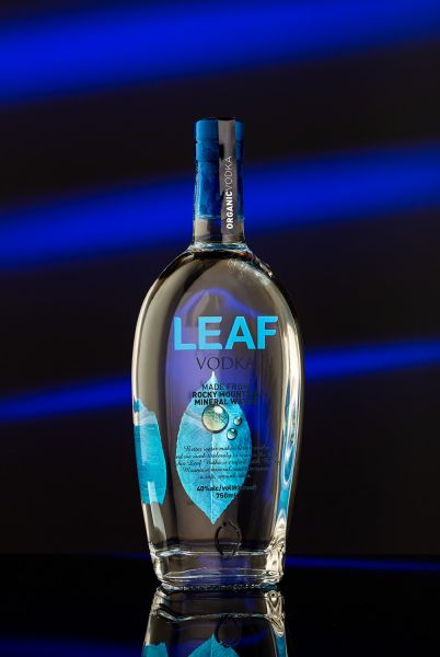 Leaf vodka bottle on blue striped background